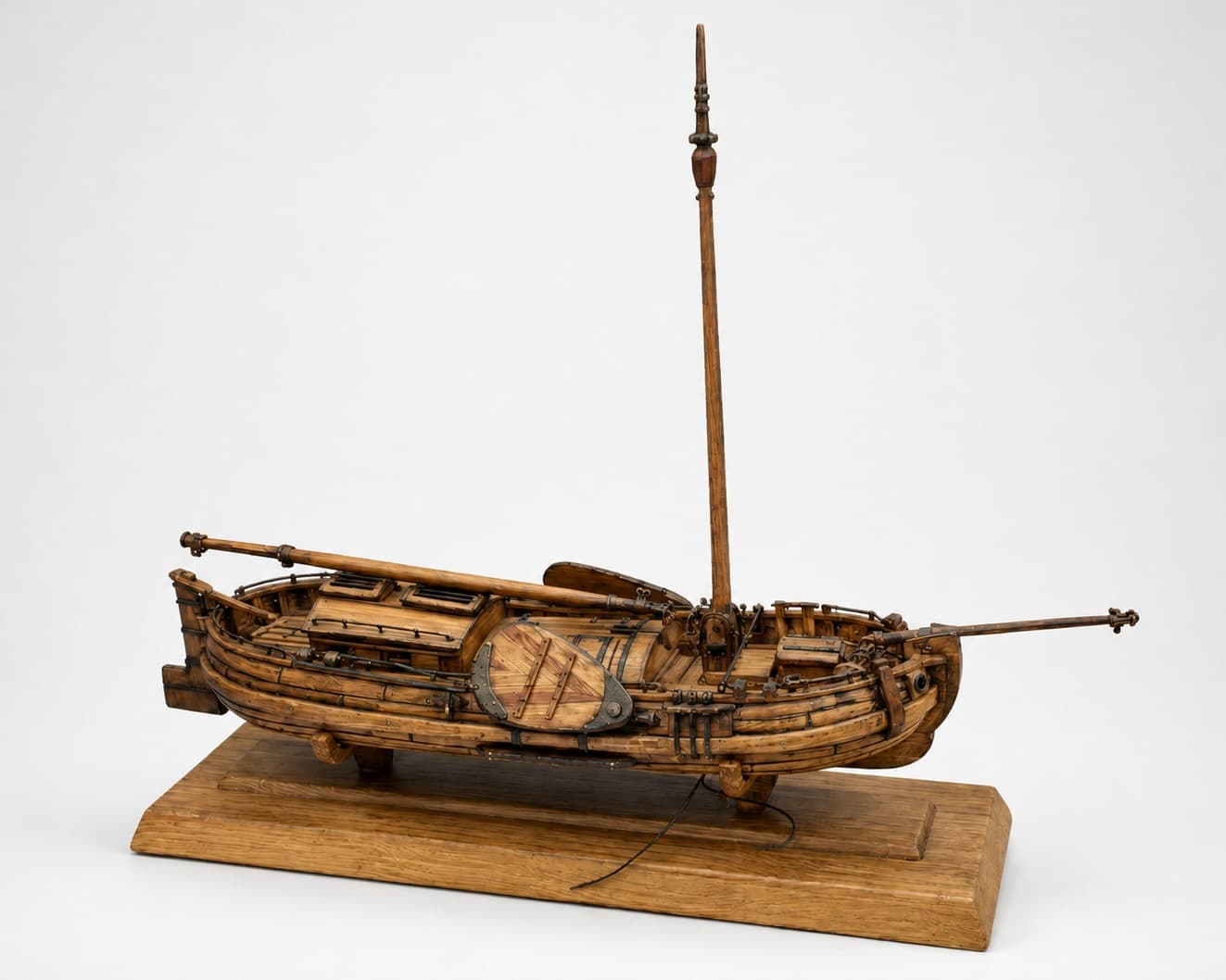 The boat on its display base with the mast stepped and the bowsprit fitted